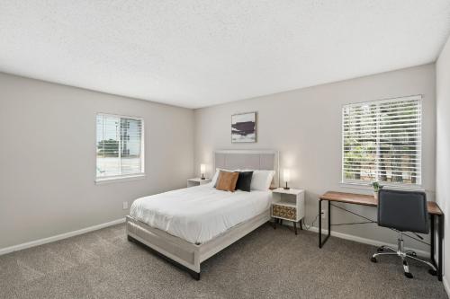 a bedroom with a bed and a desk and two windows at Comfort & Convenience in Stone Mountain in Stone Mountain