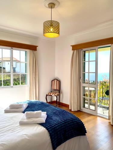 a bedroom with a bed and a large window at "Fifi House" in Estreito da Calheta