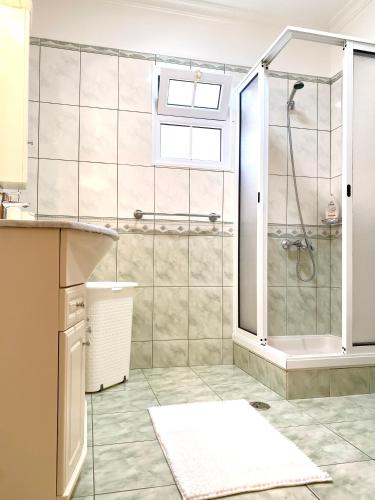 a bathroom with a shower with a glass door at "Fifi House" in Estreito da Calheta