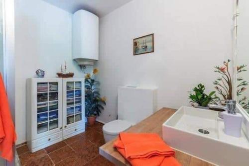 a bathroom with a white sink and a toilet at Apartment für 4 Personen mit Jacuzzi und Pool in Lovran