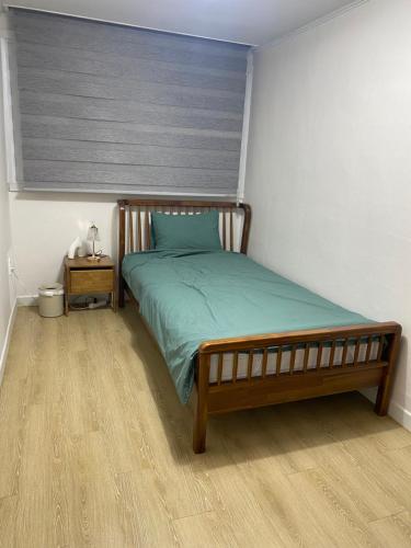a bedroom with a bed with a wooden headboard at 하우스 The 쉼 in Suwon