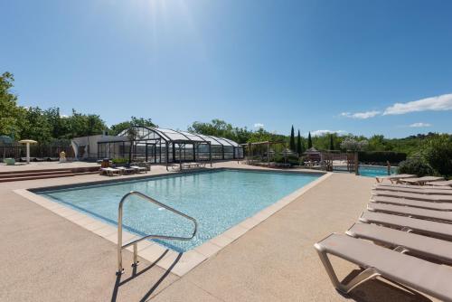 a swimming pool with lounge chairs next to at Chez gaby in Lagorce