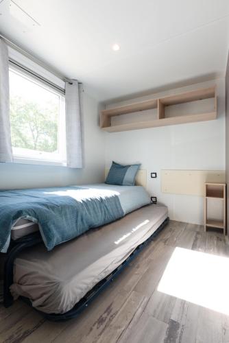a bed in a small room with a window at Chez gaby in Lagorce