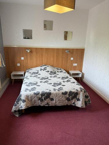 a bedroom with a large bed in a room at Hôtel La Renaissance in Arlanc