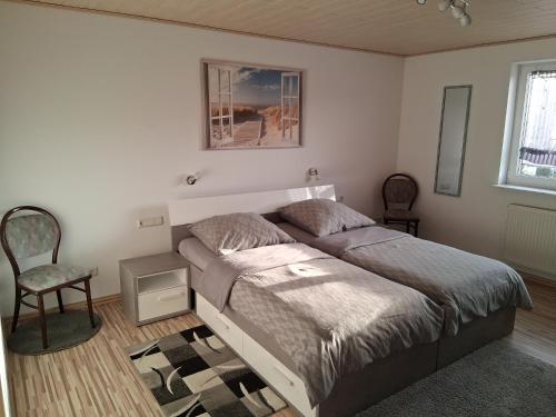a bedroom with a bed and a chair at Ferienwohnung Kany in Bliesmengen-Bolchen