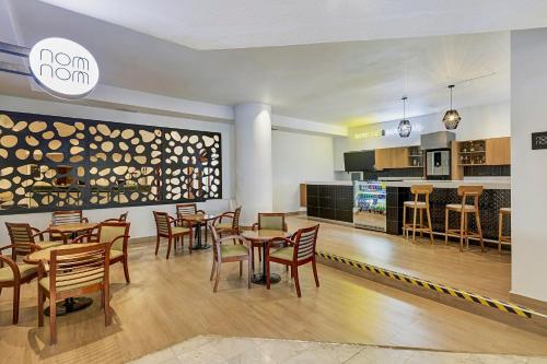 a restaurant with tables and chairs and a kitchen at Fiesta Inn Express Chihuahua in Chihuahua