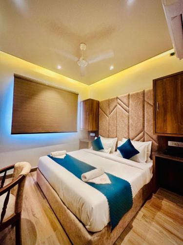 a bedroom with a large bed with blue pillows at Hotel RK Heights 300M HOTEL TO GOLDEN TEMPLE in Amritsar