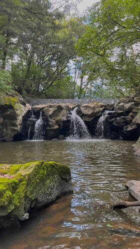 a waterfall in the middle of a river at Cabaña Sendero De Las Luciernagas in Zacatlán