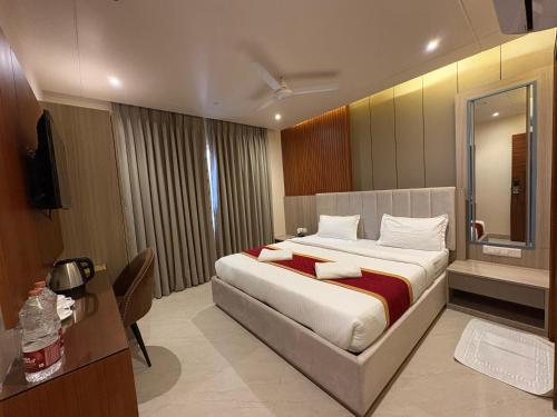 a hotel room with a bed and a television at Eve Hotel in Varanasi