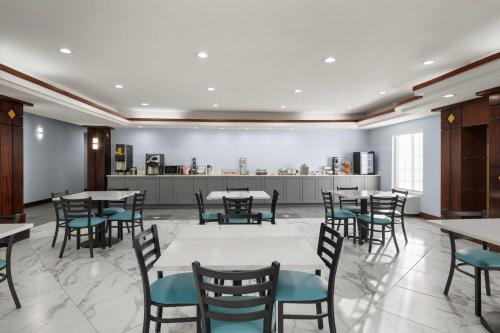 a dining room with tables and blue chairs at Days Inn by Wyndham Dodge City in Dodge City