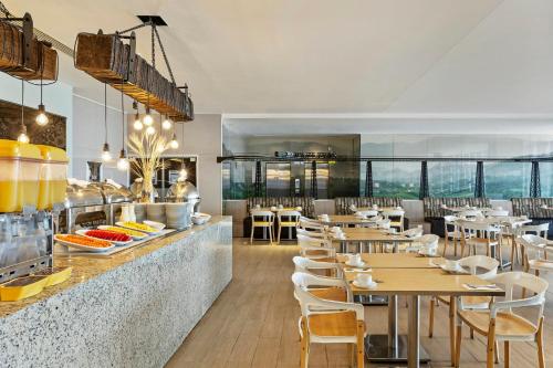 a restaurant with tables and chairs and a counter at Fiesta Inn Express Ciudad de México Forum Buenavista in Mexico City