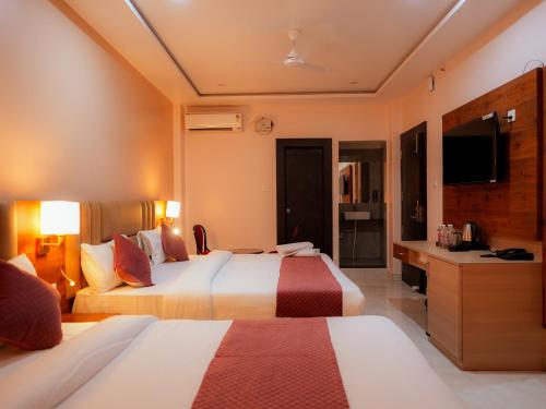 a hotel room with two beds and a television at Hotel Nirvvana Residency in Varanasi