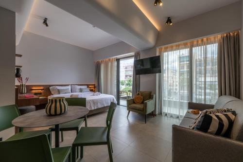 ein Hotelzimmer mit Bett, Tisch und Stühlen in der Unterkunft CENTRO Suites in Kalamata