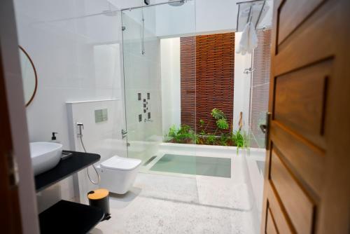 a bathroom with a shower and a toilet and a sink at The Villa - Premium Private Pool Villa in Vaduvanchal