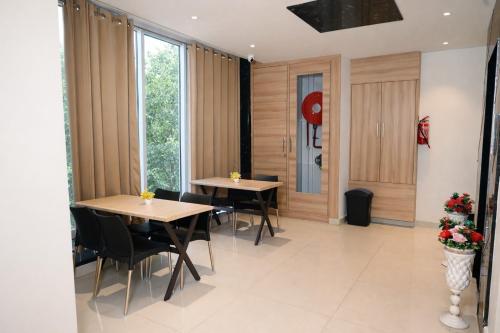 two tables and chairs in a room with windows at Hotel Diamond Villa and Banquet in Amritsar