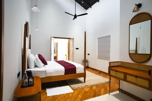 a bedroom with a bed and a dresser and a mirror at The Villa - Premium Private Pool Villa in Vaduvanchal