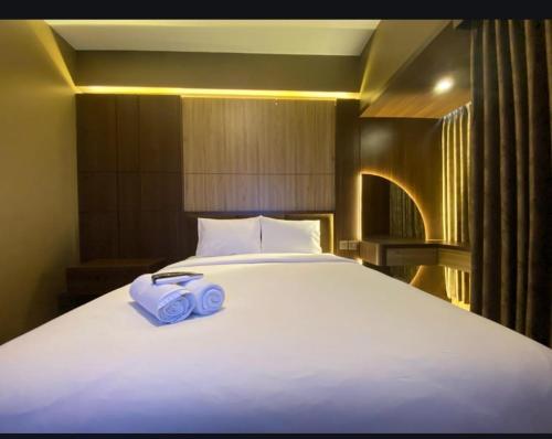 a large white bed with two blue towels on it at Alton by Be rent in Jatingaleh