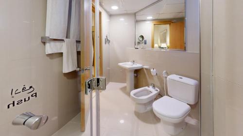 a white bathroom with a toilet and a sink at Golden Sands Hotel Apartments in Dubai