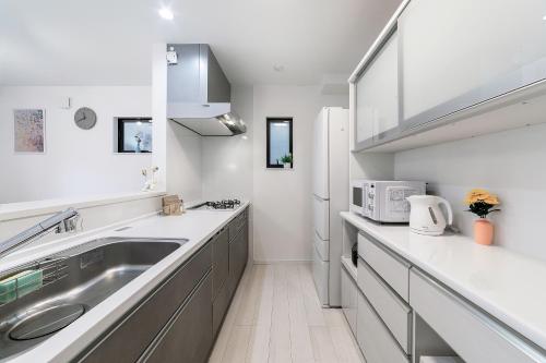 a kitchen with a sink and a microwave at 陽明宿粉浜 in Osaka