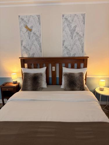 a bedroom with a large bed with two pillows at The LightHouse Chambres à louer in Châteaulin