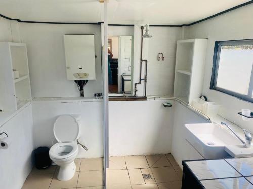 a white bathroom with a toilet and a sink at OUPAs se Plek in Kontiki