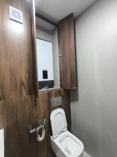 a bathroom with a toilet and a sink and a mirror at Life park Osh 2 in Osh