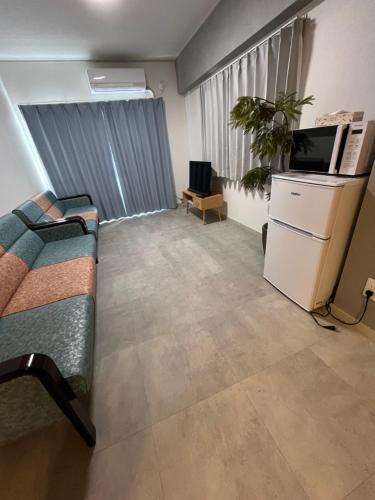 a living room with a couch and a tv at Miya's Home 102-名駅まるまる貸切メゾン in Nagoya