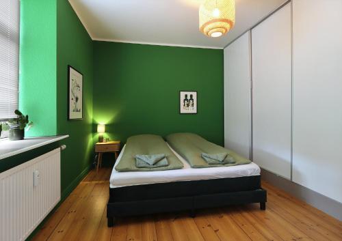 a bedroom with green walls and a bed in it at Greenbrook Homes - Family 7PPL in Aalborg