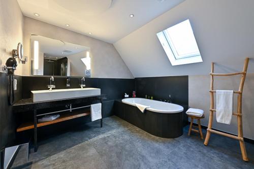a bathroom with a tub and a sink and a mirror at Höll am Main in Rüsselsheim