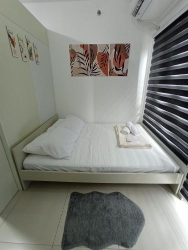 a small bedroom with a bed and a rug at SFC Cool Suites by SMDC Tagaytay in Tagaytay