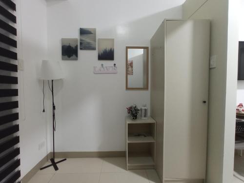 a white room with a mirror and a lamp at SFC Cool Suites by SMDC Tagaytay in Tagaytay