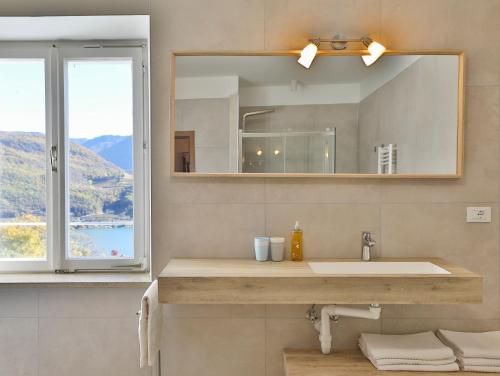 a bathroom with a sink and a mirror and a window at Arzenhof, Baron Di Pauli in Caldaro