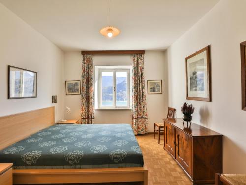 a bedroom with a bed and a desk and a window at Arzenhof, Baron Di Pauli in Caldaro