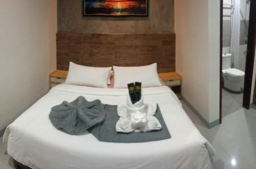 a white bed with towels and a robe on it at Kasa Boutique Hotel Bacolod in Bacolod