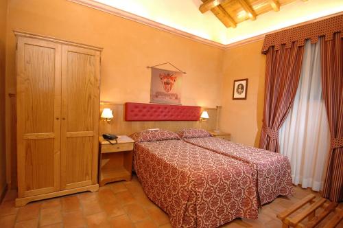 sypialnia z łóżkiem i drewnianą szafką w obiekcie Casale Certosa w mieście Pavona