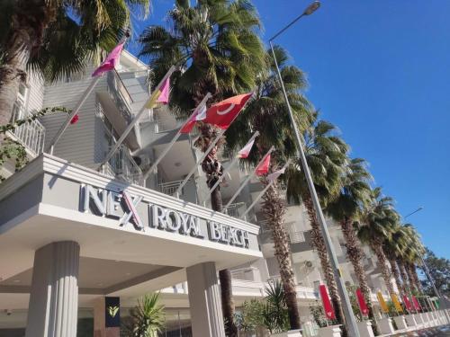 a hotel with palm trees in front of it at Nex Royal Beach in Antalya