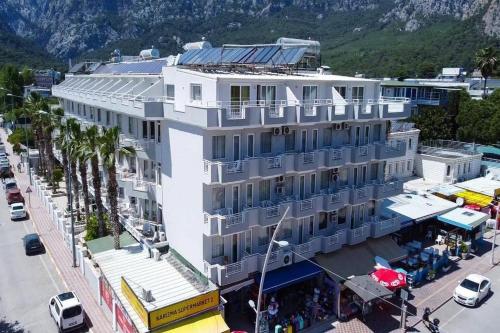 a large white building on a street with palm trees at Nex Royal Beach in Antalya