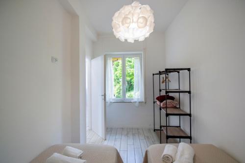 a living room with a chandelier and a couch at VivimiHome - Casa Tiberio in Conca dei Marini
