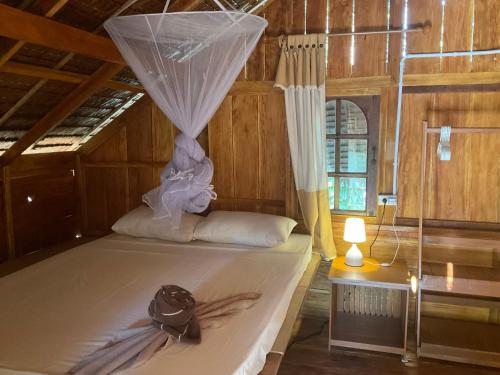 a bedroom with a bed with a mosquito net at Dawn of Happiness in Ao Nam Mao