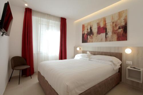 a bedroom with a large bed with red curtains at Residenza del Centro in Fabriano