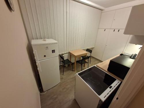 a small kitchen with a refrigerator and a table at Dombó apartman in Dombóvár