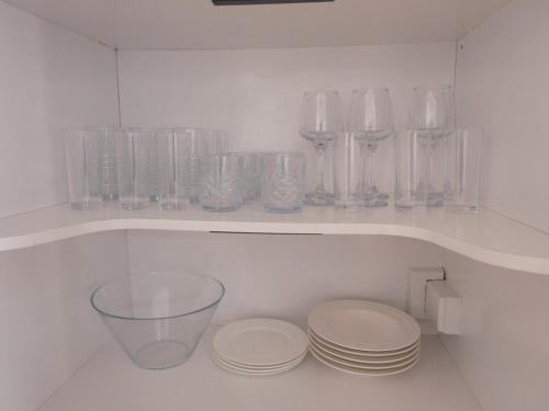 a shelf with glass vases and plates on it at Sweet Home in Avalon in Lower Hutt