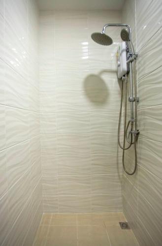 a shower with a shower head in a bathroom at TP Residence เคหะร่มเกล้า in Lat Krabang