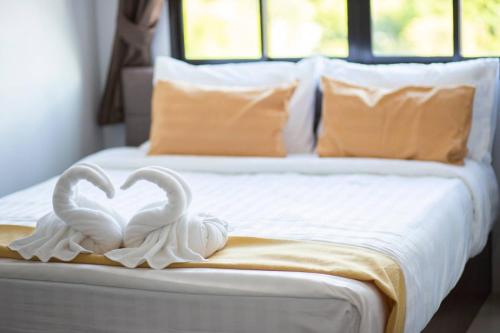 two white swans forming a heart on a bed at TP Residence เคหะร่มเกล้า in Lat Krabang