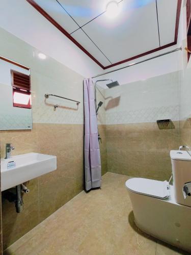 a bathroom with a toilet and a sink at Shalom Resort in Avissawella