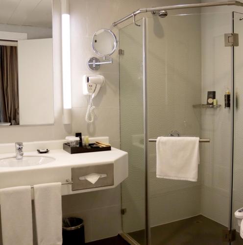 a bathroom with a sink and a shower at Holiday Villa Hotel & Residence City Centre Doha in Doha