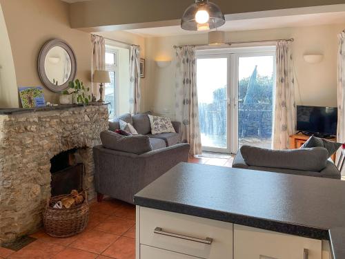 a kitchen and living room with a stone fireplace at Mimosa - Uk51224 in Swyre
