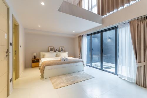 a bedroom with a bed and a large window at Heaven Thonglor 36 - Villa in Bangkok