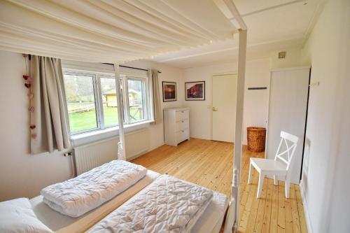 a bedroom with a bed and a chair and a window at "Hasselbacken" in Vimmerby