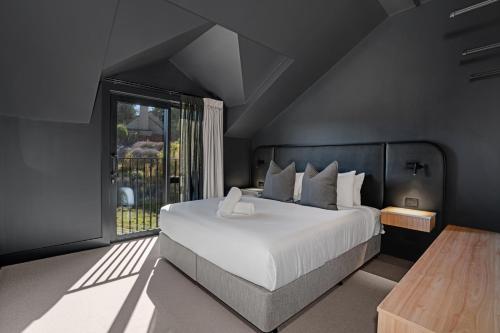 a bedroom with a large white bed and a window at Luna Lodge Wānaka - digital check-in only in Wanaka